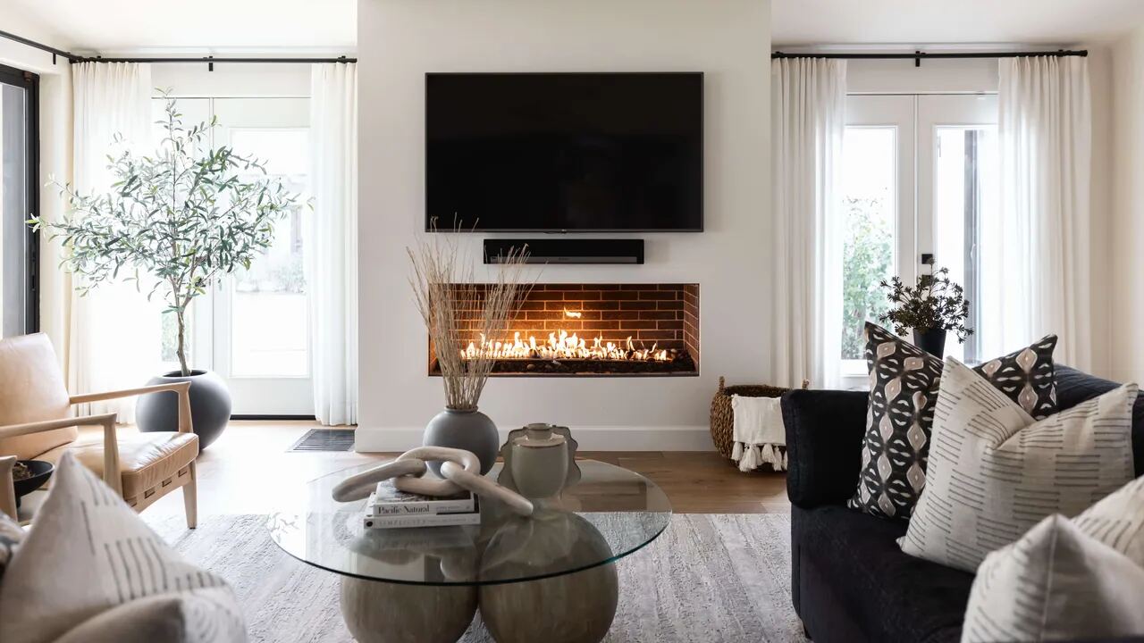 Flat screen television wall mounted above a fireplace with cables hidden and a soundbar below