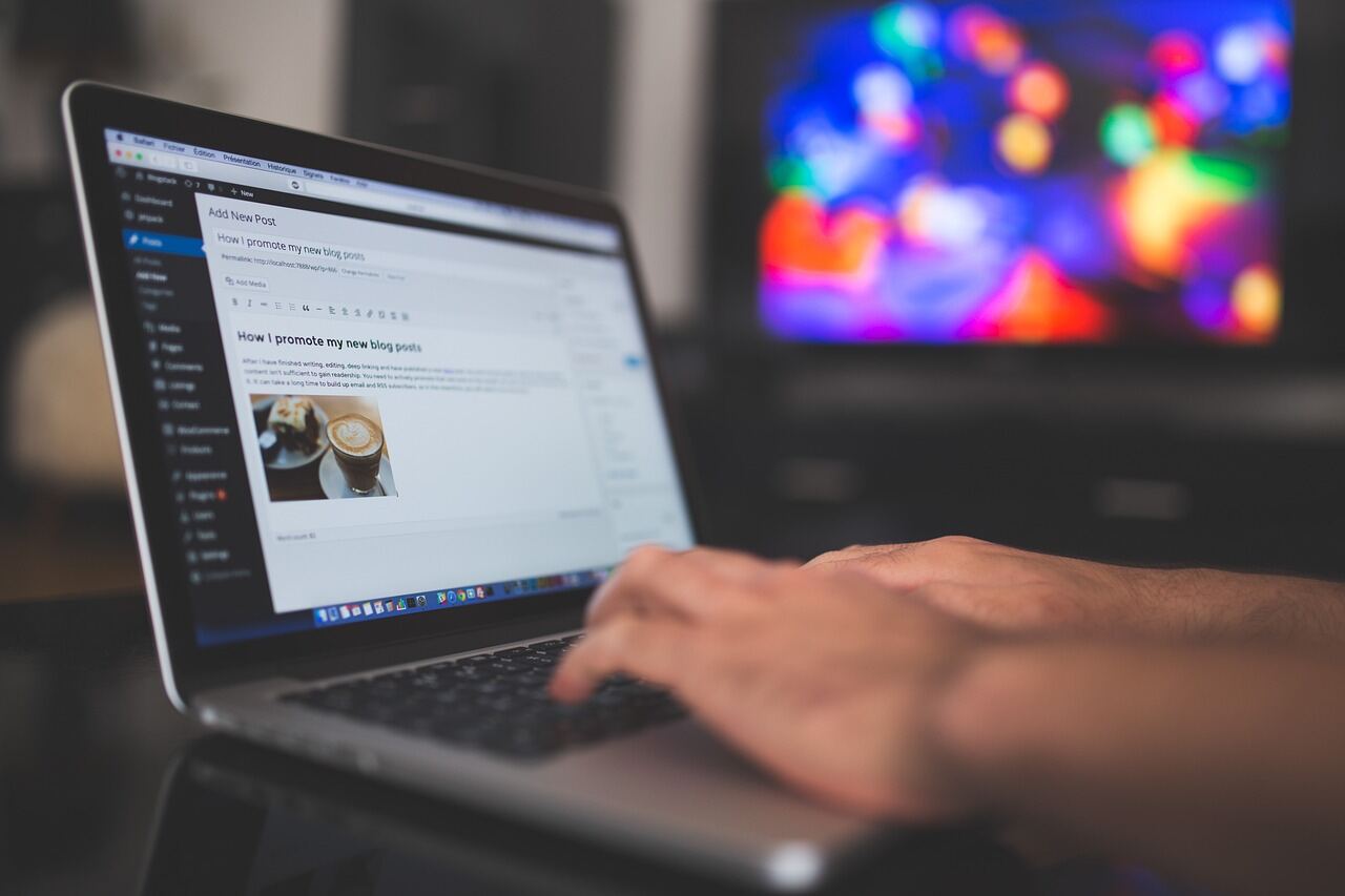 Person updating website content on a laptop